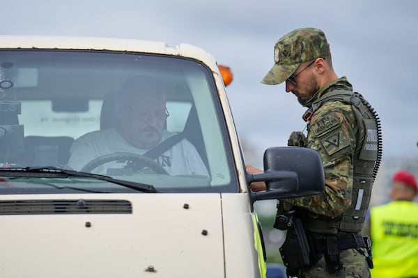 A Polish border police officer checks a vehicle at a checkpoint bordering Germany, in Slubice, Poland, Monday, July 7, 2025. (AP Photo/Ebrahim Noroozi)