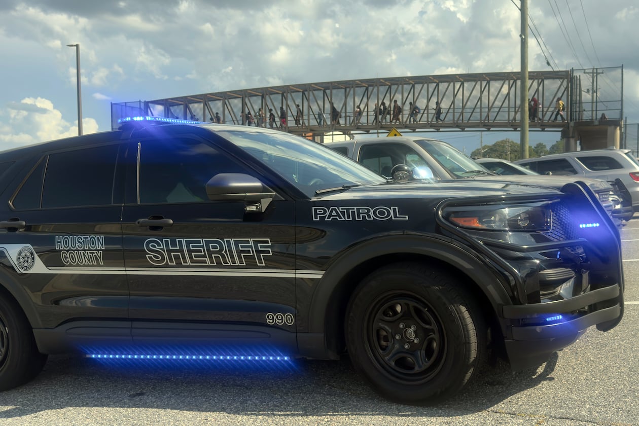 Students leave Warner Robins High School as Houston County Sheriff's vehicles remain on the scene after a shooting on campus left one injured at the Middle Georgia school on Aug. 12, 2026, officials said. Police have a suspect in custody. (Joe Kovac/AJC)