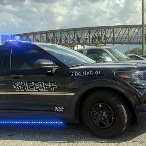 Students leave Warner Robins High School as Houston County Sheriff's vehicles remain on the scene after a shooting on campus left one injured at the Middle Georgia school on Aug. 12, 2026, officials said. Police have a suspect in custody. (Joe Kovac/AJC)