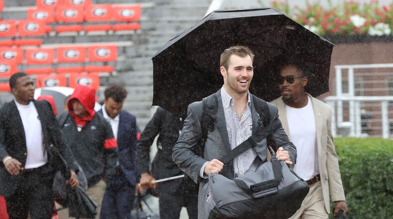 Georgia quarterback Jake Fromm is all smiles despite the wind and rain during the Dawg Walk.    Curtis Compton/ccompton@ajc.com