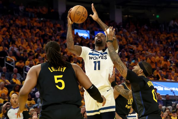 Minnesota Timberwolves center Naz Reid (11) shoots against Golden State Warriors guard Gary Payton II (0) and forward Kevon Looney (5) during the first half of Game 4 in the Western Conference semifinals of the NBA basketball playoffs Monday, May 12, 2025, in San Francisco. (AP Photo/Jed Jacobsohn)