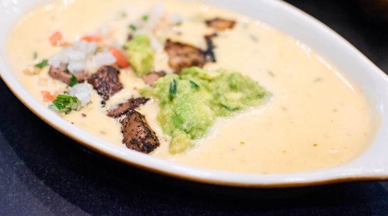 Chili con Queso Compuesto at the El Felix adds brisket, pico de gallo and guacamole. CONTRIBUTED BY HENRI HOLLIS