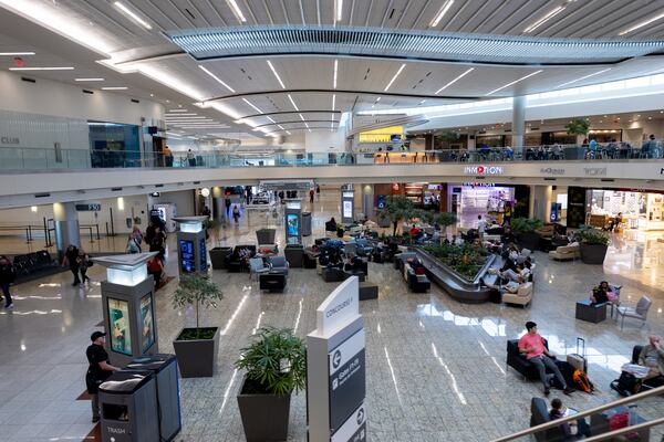 Travelers wait in Concourse F, the international terminal, at Hartsfield-Jackson airport in Atlanta on Wednesday. (Arvin Temkar /AJC)