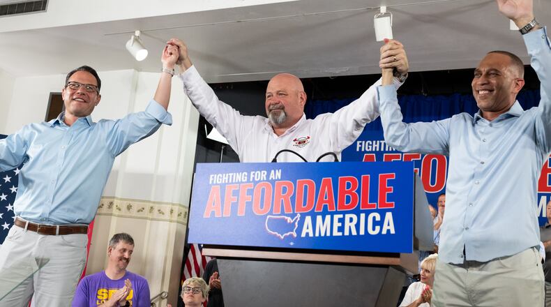 Pennsylvania Gov. Josh Shapiro, left, Democratic congressional candidate Bob Brooks, center, and U.S. House Democratic Leader Hakeem Jeffries raise their hands during a campaign event for Brooks ahead of the midterm elections at a Steelworkers Union Hall in Bethlehem, Pa., Sunday, July 26, 2026. (AP Photo/Erin Blewett)