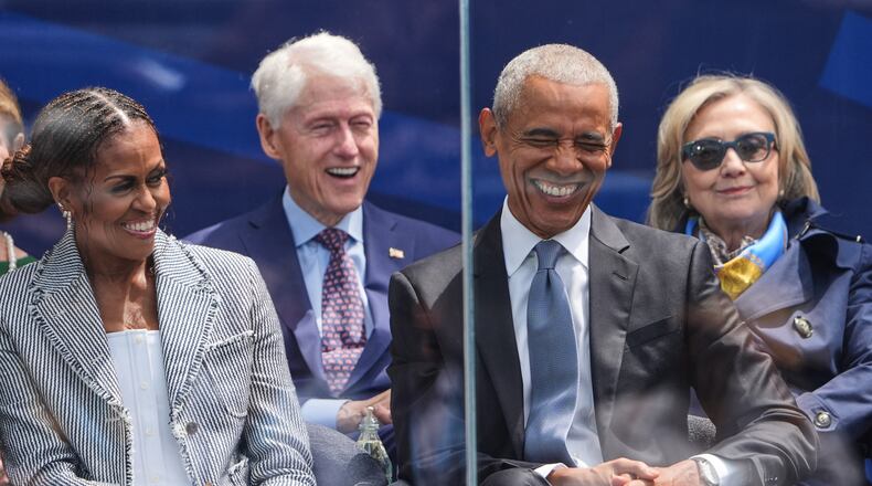 Former President Barack Obama, right, shares a laugh with former first lady Michelle Obama, left, on stage during the dedication ceremony for the Obama Presidential Center, Thursday, June 18, 2026, in Chicago. (AP Photo/Jeff Roberson)