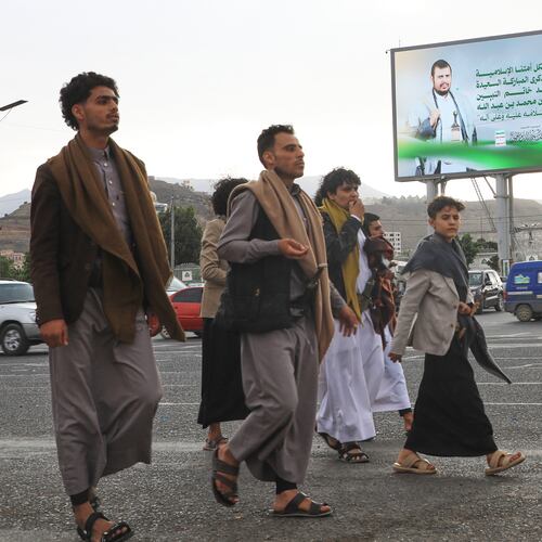 People walk under a billboard showing Houthi leader Abdul Malik al-Houthi with a phrase from the Islamic book Quran that reads in Arabic; "In the bounty of Allah and in His mercy - in that let them rejoice; it is better than what they accumulate" in Sanaa, Yemen, Sunday, Sept. 6, 2026. (AP Photo/Osamah Abdulrahman)