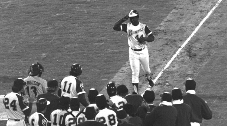 Dusty Baker (12, middle) waits with his Braves teammates at home plate as Hank Aaron approaches after Aaron's 715th home run. (AP Photo/Joe Sebo, File)