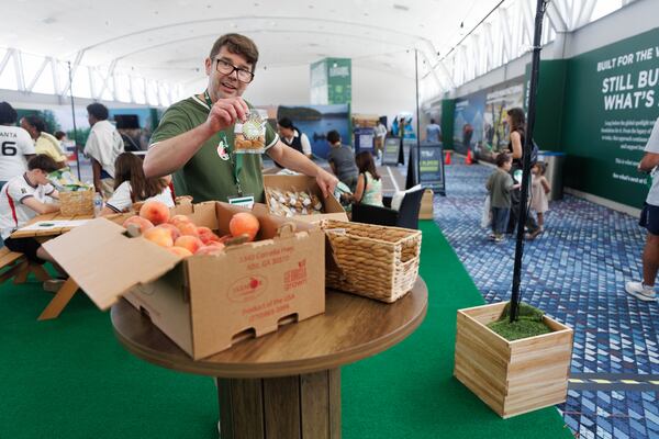 At the Explore Georgia expo Loren Heyns restocks local cookies that are offered to attendees for free at the Georgia World Congress Center in Atlanta on Wednesday, July 15, 2026. (Estela Muñoz/AJC)