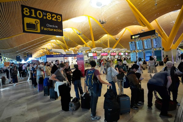 Passengers queue at Madrid airport, during a major power outage, Monday, April 28, 2025. (AP Photo/Manu Fernandez)