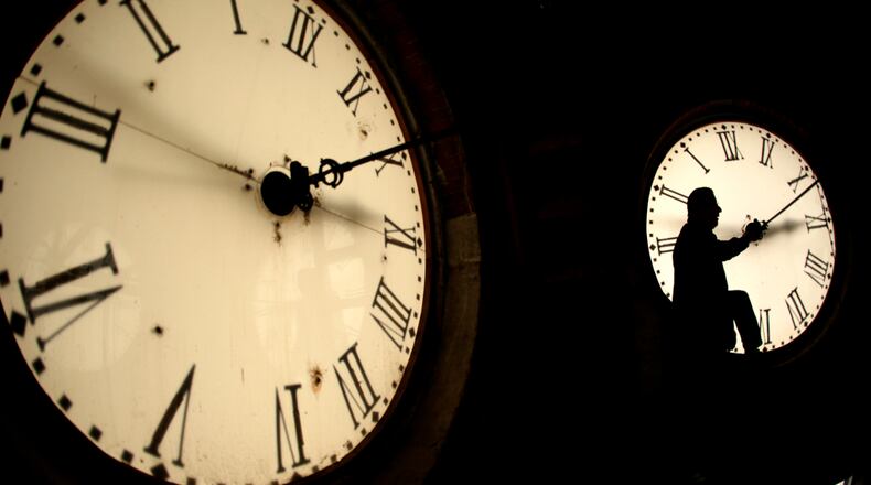 MARKING TIME--Custodian Ray Keen inspects a clock face before changing the time on the 100-year-old clock atop the Clay County Courthouse Saturday, March 8, 2014, in Clay Center, Kan. Americans will set their clocks 60 minutes forward before heading to bed Saturday night, but daylight saving time officially starts Sunday at 2 a.m. local time. (AP Photo/Charlie Riedel)
