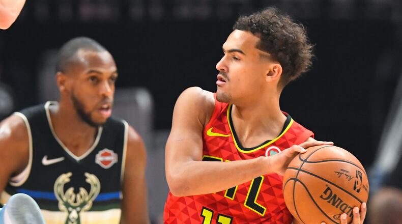 Hawks guard Trae Young (11) looks over the floor as Milwaukee Bucks forward Khris Middleton defends during the first half of an NBA basketball game Friday, Dec. 27, 2019, in Atlanta. (AP Photo/John Amis)