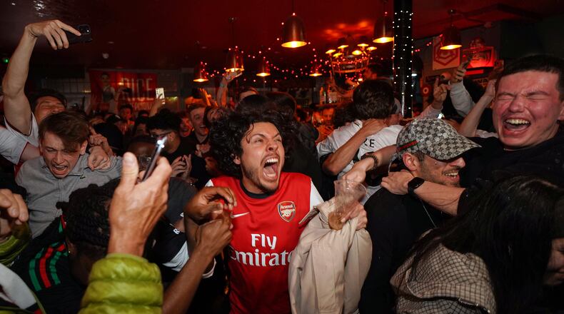 Arsenal supporters celebrate in a pub near the Arsenal stadium after Arsenal's soccer team won the Premier League title in London, Tuesday, May 19, 2026.(AP Photo/Alberto Pezzali)