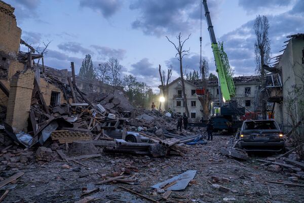 Rescue workers clear the rubble after a Russian strike in a residential neighborhood in Kyiv, Ukraine, Thursday, April 24, 2025. (AP Photo/Alex Babenko)