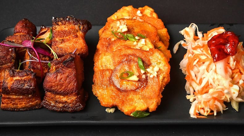 West Midtown’s Rock Steady has a menu based on dishes of the Afro-Caribbean diaspora, including these dishes from Haiti, (from left) griot (braised pork shoulder), tostones (fried plantains) and pikliz (a vinegar-based slaw). STYLING BY CHRISTIAN LUCKE BELL / CONTRIBUTED BY CHRIS HUNT PHOTOGRAPHY