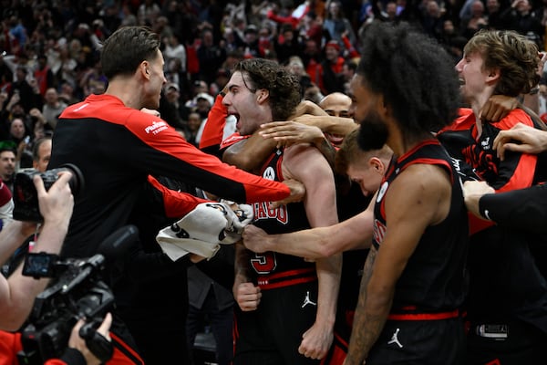 Chicago Bulls' Josh Giddy (3) celebrates with teammates after making the winning basket in an NBA basketball game against the Los Angeles Lakers Thursday, March 27, 2025, in Chicago. (AP Photo/Paul Beaty)