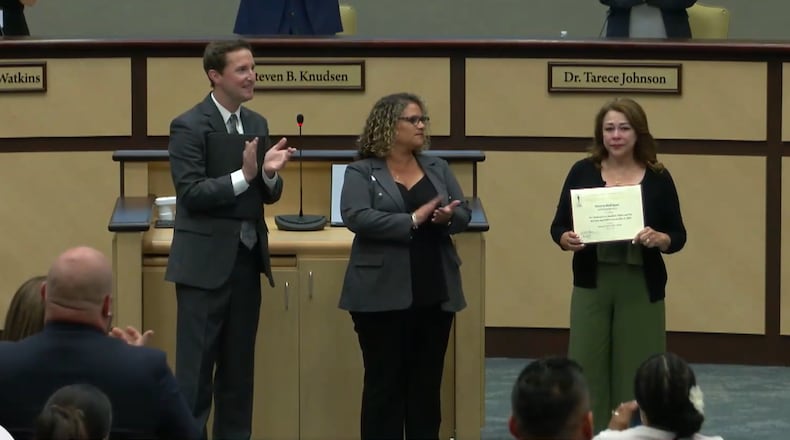During a Gwinnett County school board meeting on Thursday, Patricia Rodriguez (right) accepted a certificate of recognition for getting students on her bus safely to school after the bus was shot several times on May 9. (Courtesy of Gwinnett County Public Schools)