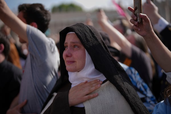 A nun cries as the body of Pope Francis is carried into St. Peter's Basilica at the Vatican, Wednesday, April 23, 2025, where he will lie in state for three days. (AP Photo/Emilio Morenatti)