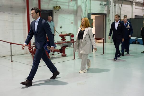 Sen. Jon Ossoff (from left), Rep. Lucy McBath and Rep. Rich McCormick walk into Dobbins Air Reserve Base on Saturday, March 28, 2026, in Marietta. The politicians shared a stage during the Georgia Service Academy Day event. (Ben Gray for the AJC)