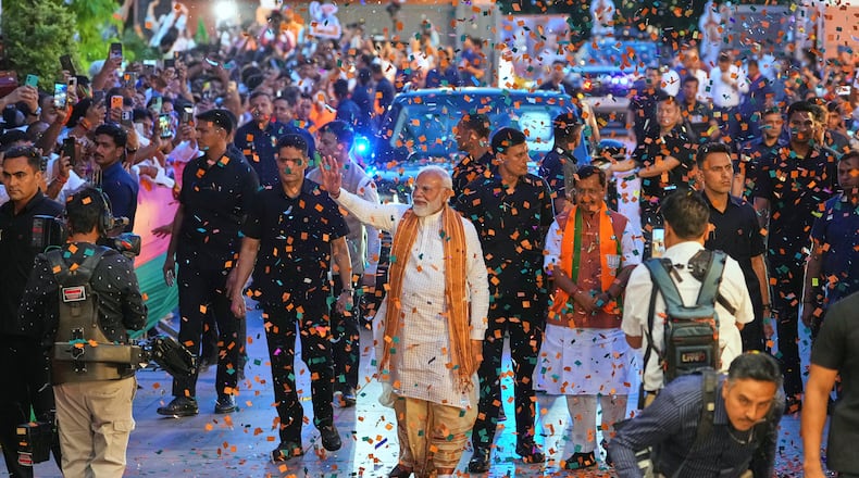 Confetti is sprayed as Indian Prime Minister Narendra Modi, center, waves to supporters upon his arrival at the Bharatiya Janata Party (BJP) headquarters to celebrate victory in the recently held state assembly elections in New Delhi, India, Monday, May 4, 2026. (AP Photo/Manish Swarup)