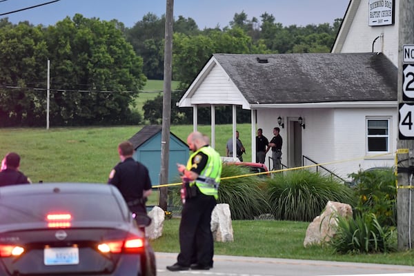 Police stand at the front of the Richmond Road Baptist Church as other officers maintain a perimeter following a shooting at the church in Lexington, Ky., Sunday, July 13, 2025. (AP Photo/Timothy D. Easley)