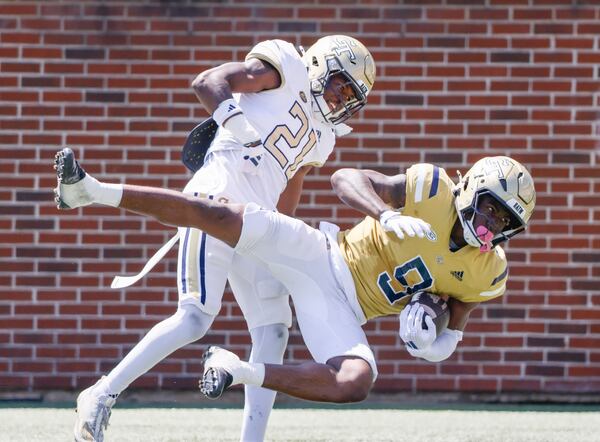 Georgia Tech wide receiver Zion Taylor (right) gets airborne after a completion in Saturday's White and Gold game.