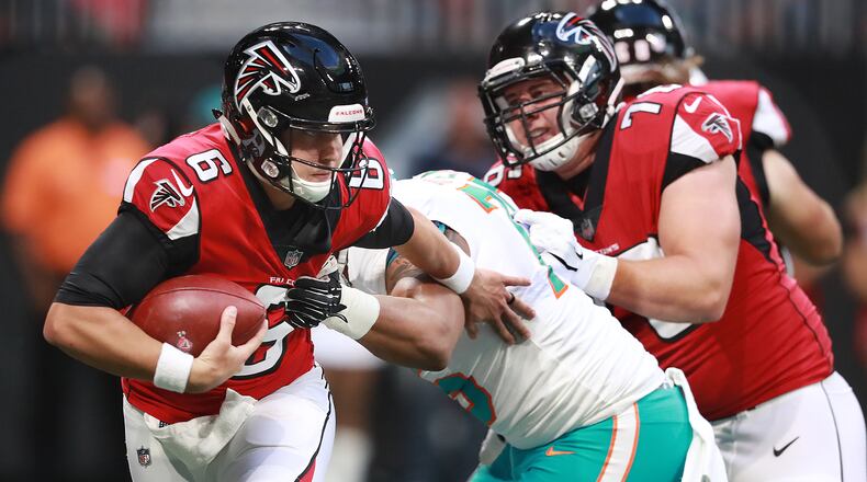 Falcons quarterback Kurt Benkert slips away from pressure by Miami Dolphins defensive end Cameron Malveaux during the first quarter Thursday, August 30, 2018, in Atlanta.
