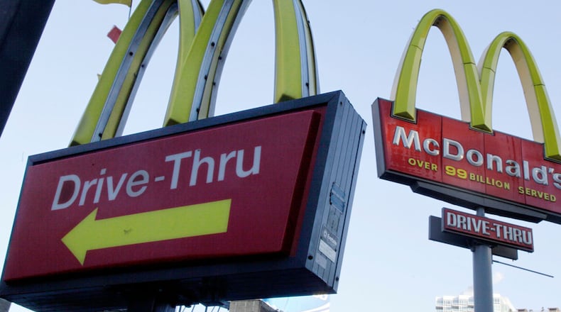 In this Dec. 20, 2010, file photo, McDonald's signs sprout from the restaurant's parking lot in New York. The Chicago Tribune reported on May 27, 2016, that a blind Louisiana man is suing the chain over its refusal to serve customers at drive-thru windows who aren't in vehicles. (AP Photo/Richard Drew, File)