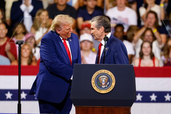 President Donald Trump (left) shakes hands with Republican nominee for governor Rick Jackson at Wheeler High School in Marietta on Wednesday. (Arvin Temkar/AJC)