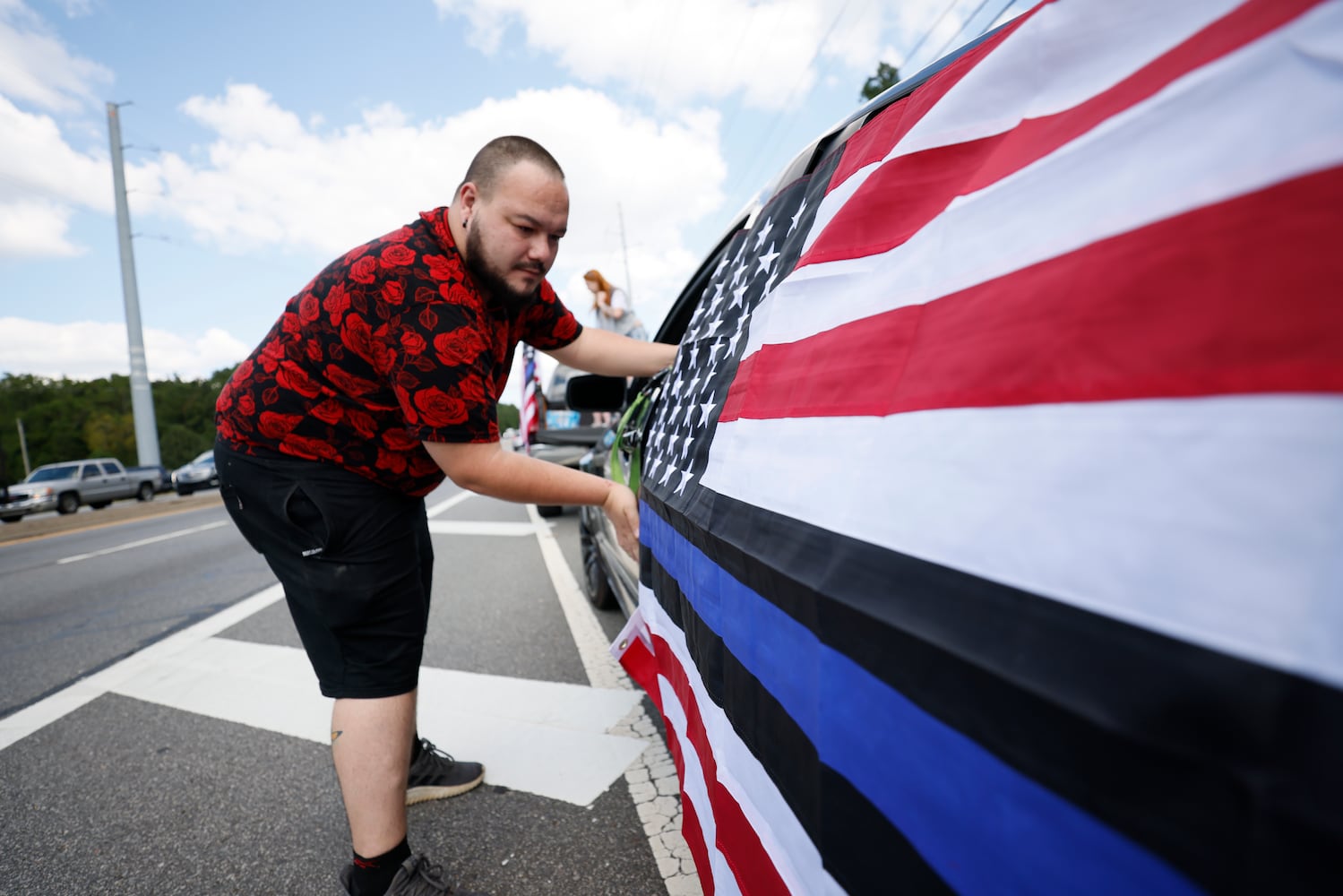 Kirk Poss from Dallas puts the U.S. over his car to pay respect to Marshall Samual Ervin Jr before the procession starts in Dallas on Thursday, September 15, 2022. Miguel Martinez / miguel.martinezjimenez@ajc.com 