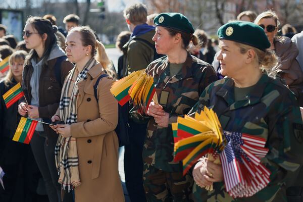 Lithuanian Army soldiers and people with U.S. and Lithuanian national flags attend a solemn farewell ceremony at Cathedral Square in Vilnius, Lithuania, Thursday, April 3, 2025 for the US soldiers who died during training exercise. (AP Photo/Mindaugas Kulbis)