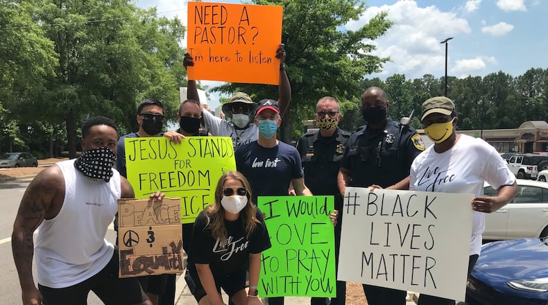 Dunwoody Police Chief Billy Grogan (third from right) takes a photo with protesters during a Tuesday afternoon demonstration. VIA DUNWOODY POLICE