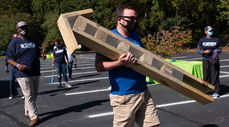 Brendon Briggs, who works in talent acquisition for Cox Enterprises, drops off an insect house he built for use in an outdoor learning lab at Harper-Archer Elementary School in Atlanta on Tuesday, Oct. 13, 2020. Ben Gray for the Atlanta Journal-Constitution