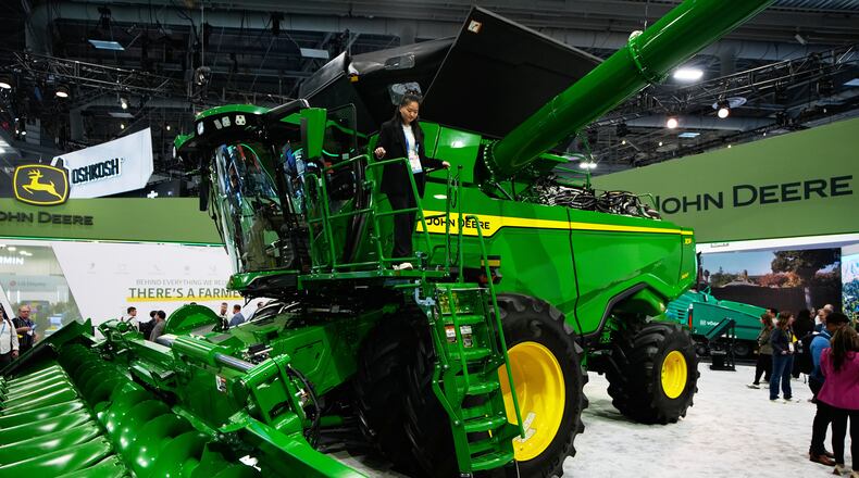 FILE - A person walks on an X9 1100 combine at the John Deere booth during the CES tech show, Jan. 6, 2026, in Las Vegas. (AP Photo/John Locher, File)