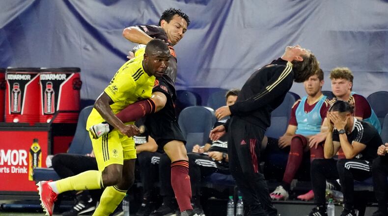 Atlanta United coach Gabriel Heinze, right, reacts to a play as Nashville SC defender Nick Hinds, left, and Atlanta defender George Bello (21) vie for the ball during the first half of an MLS soccer match Thursday, July 8, 2021, in Nashville, Tenn. (AP Photo/Mark Humphrey)