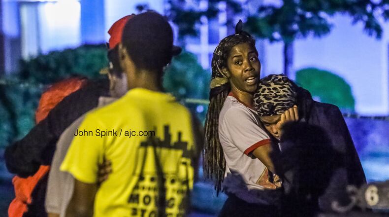 Family members and friends gather outside a home on Olmadison Place in South Fulton on Friday morning after a 21-year-old man was shot and killed.