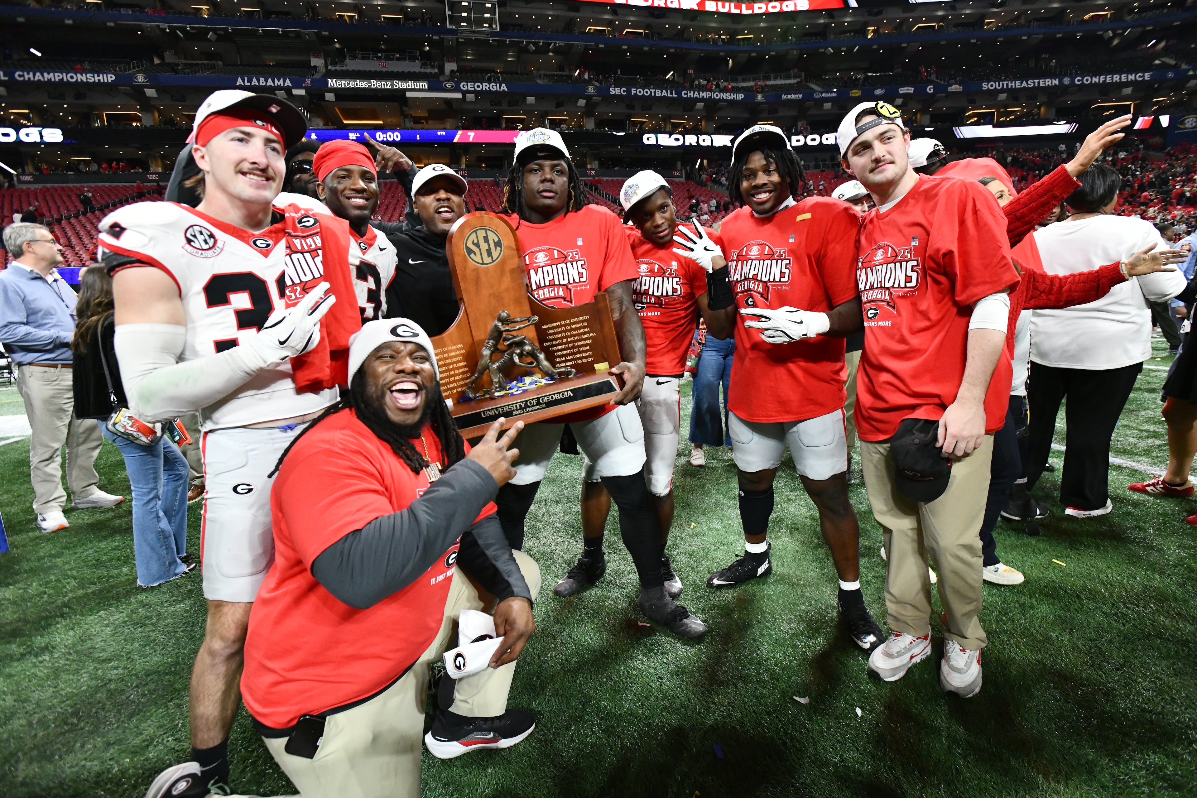 Georgia players pose with the championship trophy as they celebrate after defeating Alabama 28-7 in the SEC Championship football game at the Mercedes-Benz Stadium, Saturday, December 6, 2025 in Atlanta. (Hyosub Shin / AJC)