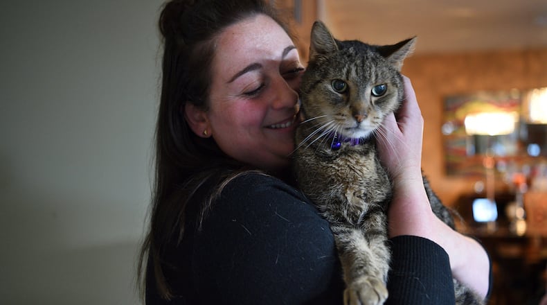 Paige Zelitsky, 23, snuggles with Jimmy, a brown tabby, on Tuesday, April 4, 2017 in Wanaque, N.J.  The cat disappeared after being let out of its Wanaque home on Sept. 13, 2014. The West Milford Animal Shelter Society says Jimmy was found in the town's High Crest section during the March blizzard. (Amy Newman/The Record via AP)