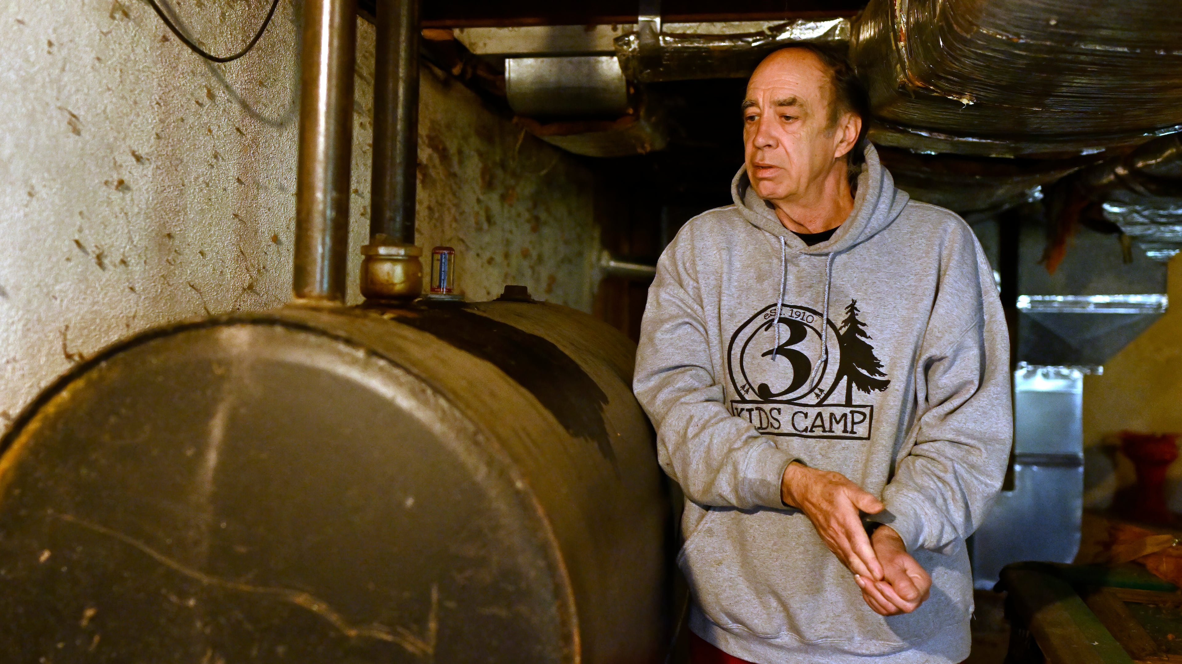 Mark Bain, who is part of the Low Income Home Energy Assistance Program, rubs his hands together as he checks the level on his oil at home in hopes that he will have enough oil to outlast the shutdown, in Bloomfield, Conn., Monday, Oct. 27, 2025. (AP Photo/Jessica Hill)