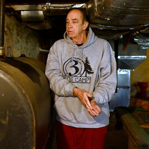 Mark Bain, who is part of the Low Income Home Energy Assistance Program, rubs his hands together as he checks the level on his oil at home in hopes that he will have enough oil to outlast the shutdown, in Bloomfield, Conn., Monday, Oct. 27, 2025. (AP Photo/Jessica Hill)