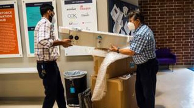 Faizan Aly, managing director (L) and Co-founder of Aguair Itamar Kleinberger unpacking the donated equipment, their SaniCart and the ClensAir.