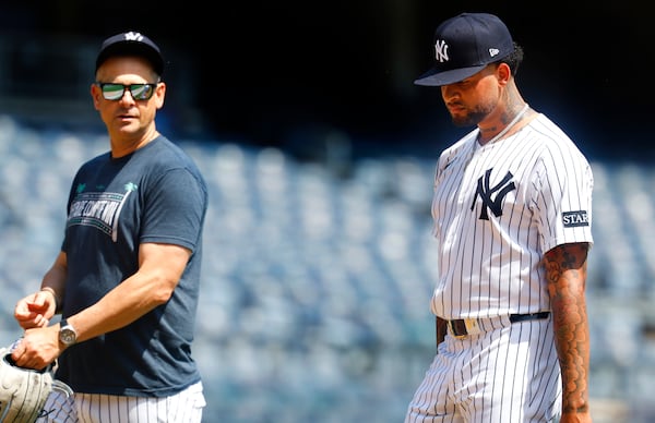New York Yankees' manager Aaron Boone and Luis Gil talk during live batting practice before a baseball game against the Baltimore Orioles, Saturday, June 21, 2025, in New York. (AP Photo/Noah K. Murray)