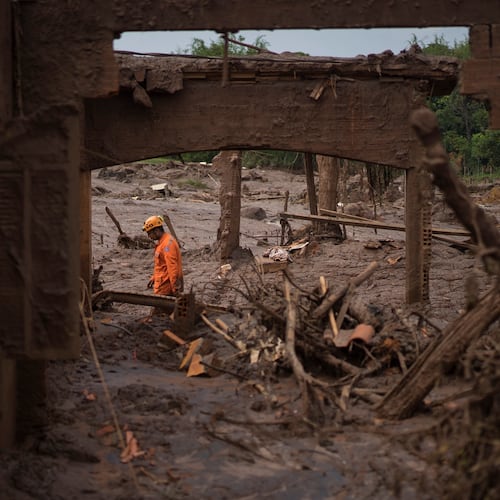 FILE - A rescue worker walks between destroyed houses after a dam burst in the town of Bento Rodrigues, Minas Gerais state, Brazil, Nov. 8, 2015. (AP Photo/Felipe Dana, File)