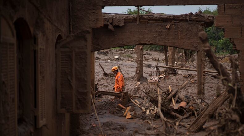 FILE - A rescue worker walks between destroyed houses after a dam burst in the town of Bento Rodrigues, Minas Gerais state, Brazil, Nov. 8, 2015. (AP Photo/Felipe Dana, File)