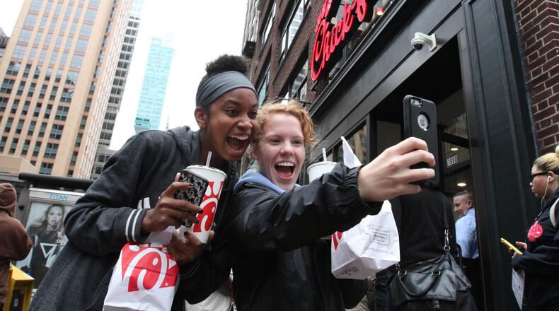 Jaimie Cranford, right, takes a photograph with Mariah Reives outside the Chick-fil-A store in New York on the store’s opening day. Cranford, originally from South Carolina, and Reives, originally from North Carolina, currently live in New York. (AP Photo/Tina Fineberg)