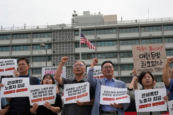 Protesters rally against the detention of South Korean workers during an immigration raid in Georgia, near the U.S. Embassy in Seoul, South Korea on Tuesday. The signs read: "A tariff bomb and workers confinement."