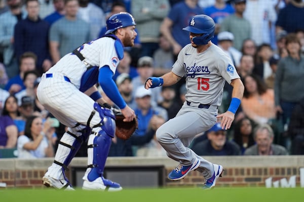 Los Angeles Dodgers' Austin Barnes (15), right, slides by Chicago Cubs catcher Miguel Amaya (9) to score on a single from Teoscar Hernández during the third inning of a baseball game, Wednesday, April 23, 2025, in Chicago. (AP Photo/Erin Hooley)