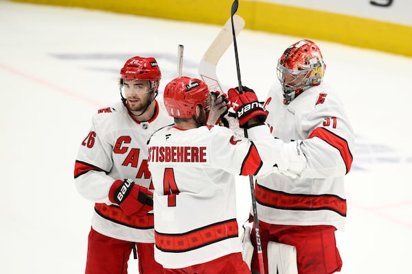Carolina Hurricanes goaltender Frederik Andersen, right, celebrates with defenseman Shayne Gostisbehere (4) and defenseman Sean Walker (26) after Game 5 of a second-round NHL hockey playoff series against the Washington Capitals Thursday, May 15, 2025, in Washington. (AP Photo/Nick Wass)