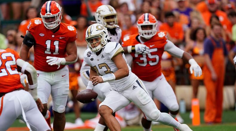 Georgia Tech quarterback Jordan Yates scrambles away from Clemson defenders Bryan Bresee (11) and Justin Foster (35) early in Saturday's game at Clemson. (AP Photo/John Bazemore)