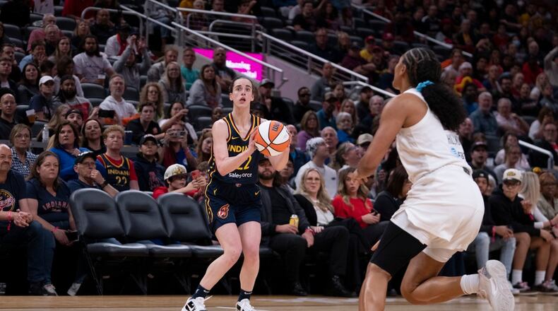 Indiana Fever's Caitlin Clark (22) puts up a 3-point shot in front of Atlanta Dream's Naz Hillmon during the second half of a WNBA preseason basketball game Thursday, May 9, 2024, in Indianapolis. (AP Photo/Darron Cummings)
