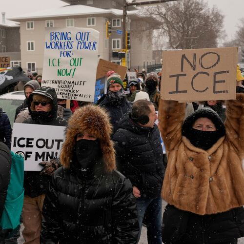 People gather near the post office during a protest, Sunday, Jan. 18, 2026, in Minneapolis. (AP Photo/Yuki Iwamura)